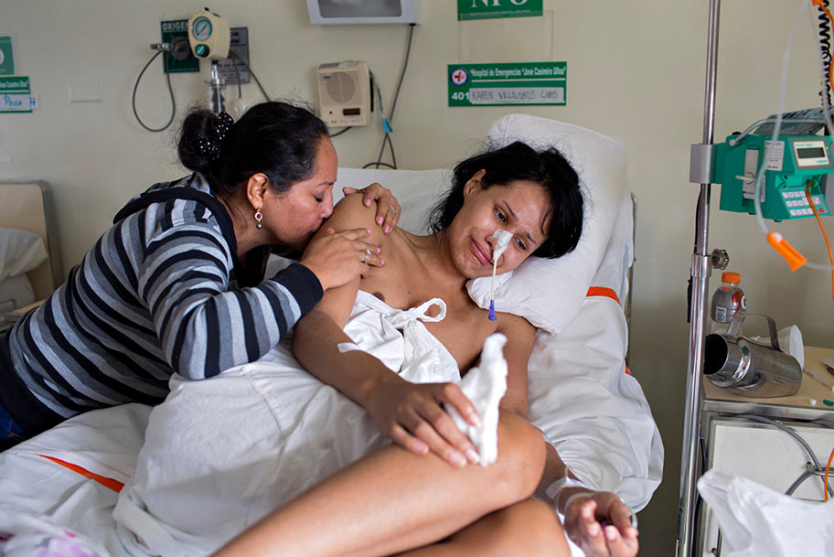 Colombian transwoman, Karen, right, is comforted by her mother, left, who flew to Peru after hearing that Karen was shot by a police officer. That evening, police officers insulted Karen and her friend during a nightly patrol, which targets trans prostitutes who are arrested without reason. Angry, Karen's friend threw a rock at their vehicle. When Karen turned to run, she was shot in the stomach. "In this country for the fact of being trans, you are not valued as a human being. Even though I was between life and death, I was still considered guilty," said Karen.  This photo from A Light Inside, a project about the lives of trans women in Latin America, makes me want to comfort Karen, makes me weep for her pain, and want to protect women like her. This entire project goes beyond stereotypes and depicts the real and very dangerous environment these women live in just for being themselves. Photo by Danielle Villasana.