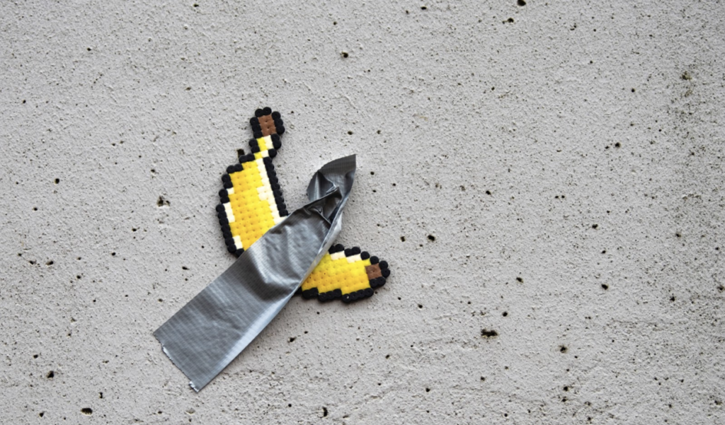 Pixelated banana duck taped to concrete wall