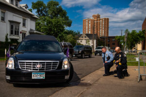 Minneapolis Police Chief Medaria Arradondo, right, kneels as the hearse of George Floyd arrives to North Central University ahead of funeral service on Thursday, June 4, 2020, in Minneapolis, MN. Protests in the wake of the death of George Floyd while in police custody has erupted across the country.