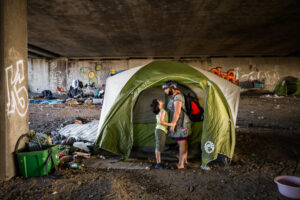 (L-r) Homeless child Theo Schrager, 7, holds on to his mom Leah Naomi GonzalesÕ hand as he cries out ÒPuppies, I want puppies.Ó as they look for puppies at their friends tent under the Gilman Street underpass in Berkeley, California, on Friday, June 12, 2020. They spent the afternoon looking for their friend Elf who has two new puppies. Theo loves dogs and desperately wants one. ÒMama, I want one and I want one now.Ó Theo declared. She answered, Ò Theo, I have way too much to take care of. ThereÕs just no way we can have a dog in that hotel room.Ó