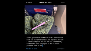 Alt text: A screenshot of the Twitter alt-text editor. Hannah is using dark mode, so the editor appears on a black background. The heading reads “Write alt-text.” And it is above an image with the following alt-text description written beneath: Forest green crocheted fabric with a pink crochet hook sits on Hannah’s lap in the airplane. She’s in a Southwest plane and the red and white safety card can be seen poking out of the blue seat pocket in front of her.”