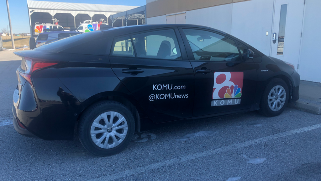 A black sedan with the KOMU Channel 8 logo, website and social media handles. KOMU provides a loaner car for employees. Photo courtesy of Kellie Stanfield