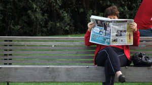 Image of woman reading newspaper by photographer Megan Trace