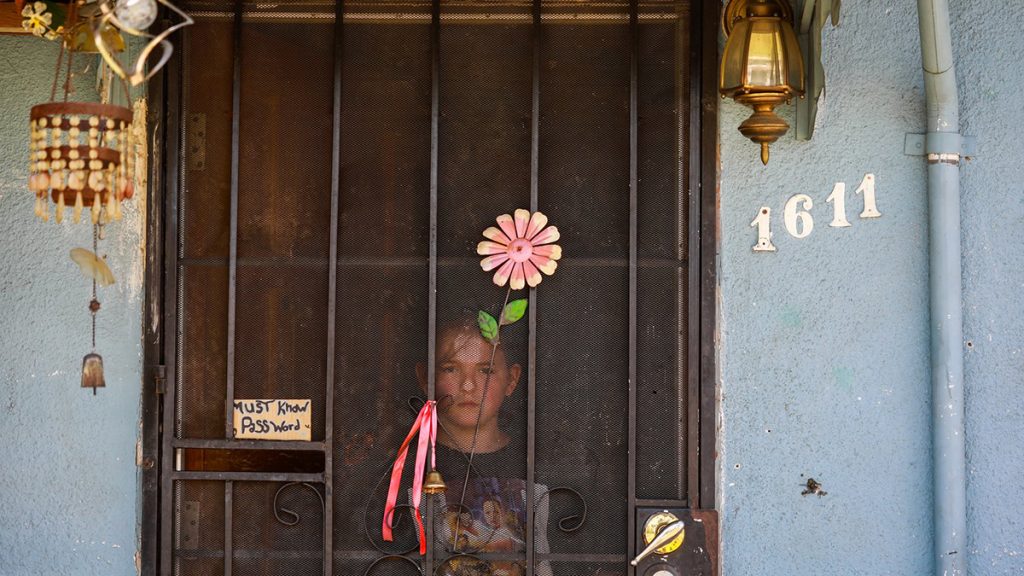 Bre-Anna Valenzuela, 10, looks out from the front door of her grandmother’s home as her family fights with one another just days after Bre-Anna’s family was evicted from their home on Thursday, April 1, 2021 in Fresno, California. | Photo: Gabrielle Lurie, POY Photographer of the Year, Local, 2022