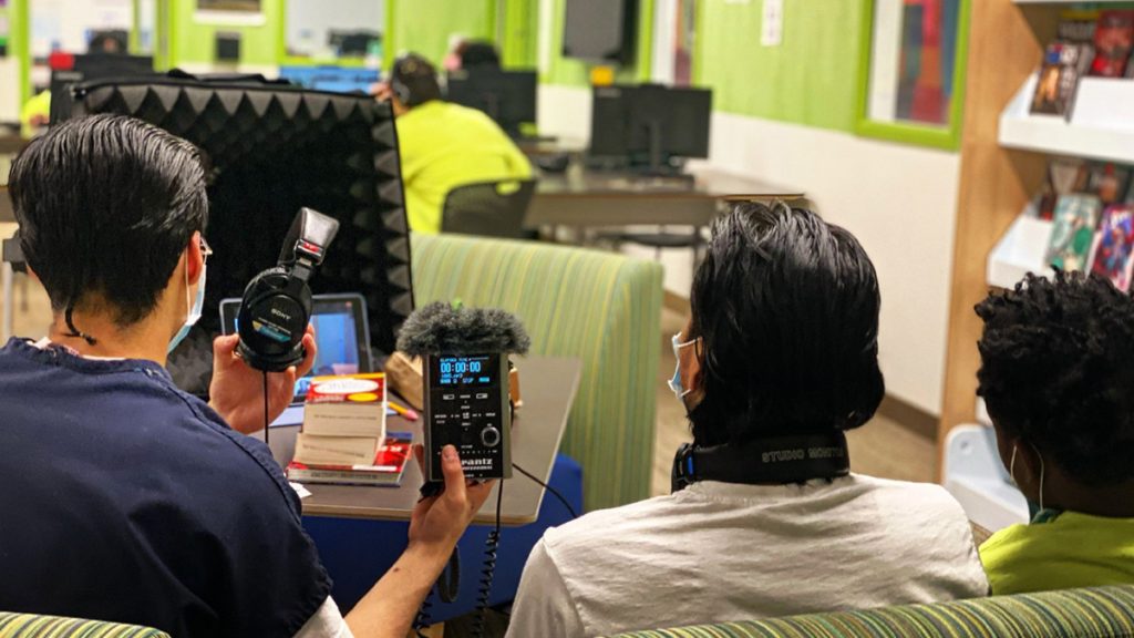 Three teens get ready to record an interview in the library at the Judge Patricia H. Clark Children and Family Justice Center in Seattle, Washington during a RadioActive Youth Media podcasting workshop on April 15, 2021. Photo: Megan Sobchuk