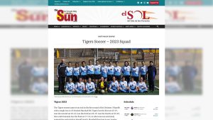 A screenshot of a webpage mockup for the Sun. There is a turquoise banner running horizontally across the top of the page, with navigation options for the website written in white, serif text on the left side. White social media buttons and a red button that read “Support Us” is on the right of the banner. Below the banner is a white space with the Sun’s logos. The left logo is in English and the right logo is in Spanish. A dark gray banner runs horizontally below the banners, with additional navigation options in white, serif text. The bottom half of the screenshot shows a photo of a girl’s soccer team. The players are wearing white and blue jerseys. There is a coach to the left of them and a coach to the right of them. The coaches are wearing black. Above the photo is the title of the page and the league for the team. It is titled “Tiger’s Soccer — 2023 Squad.” Below the photo to the left is a caption and a paragraph describing the team’s season. Below the photo to the right is the team’s schedule.