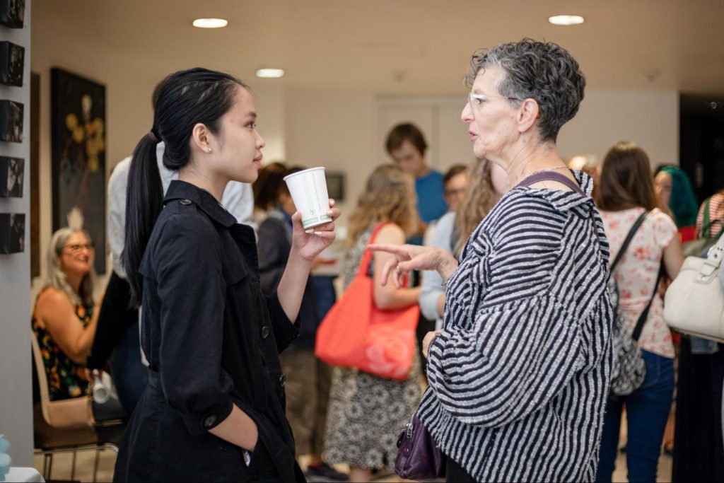 RadioActive youth producer Hong Ta speaks to arts reporter Marcie Sillman at a RadioActive Listening Party in 2019. Sillman was the editor on Ta’s first feature story. Photo: Amy Piñon | KUOW
