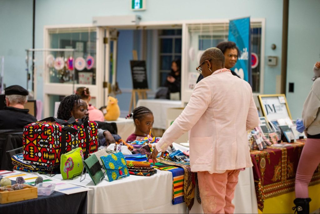 Customers chat and purchase items from local vendors at The Green Line's Winter Marketplace event for its January action journey.