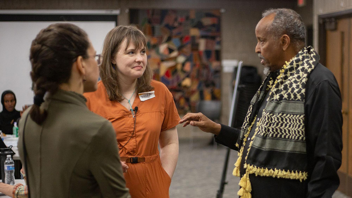 Project Optimist founder Nora Hertel (center) talks with a Jama Alimad (right), an elder in St. Cloud's Somali community, and Sara Nimis (left), a volunteer moderator in the Shades of Purple dialogue series, during the first dialogue event May 13, 2023 at the Stearns History Museum in St. Cloud, Minn.