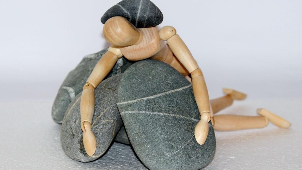 Artist's mannequin trapped between large rocks.