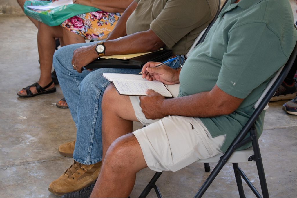 Un grupo de personas toma notas durante una reunión sobre cómo operan los radioaficionados en Puerto Rico.
