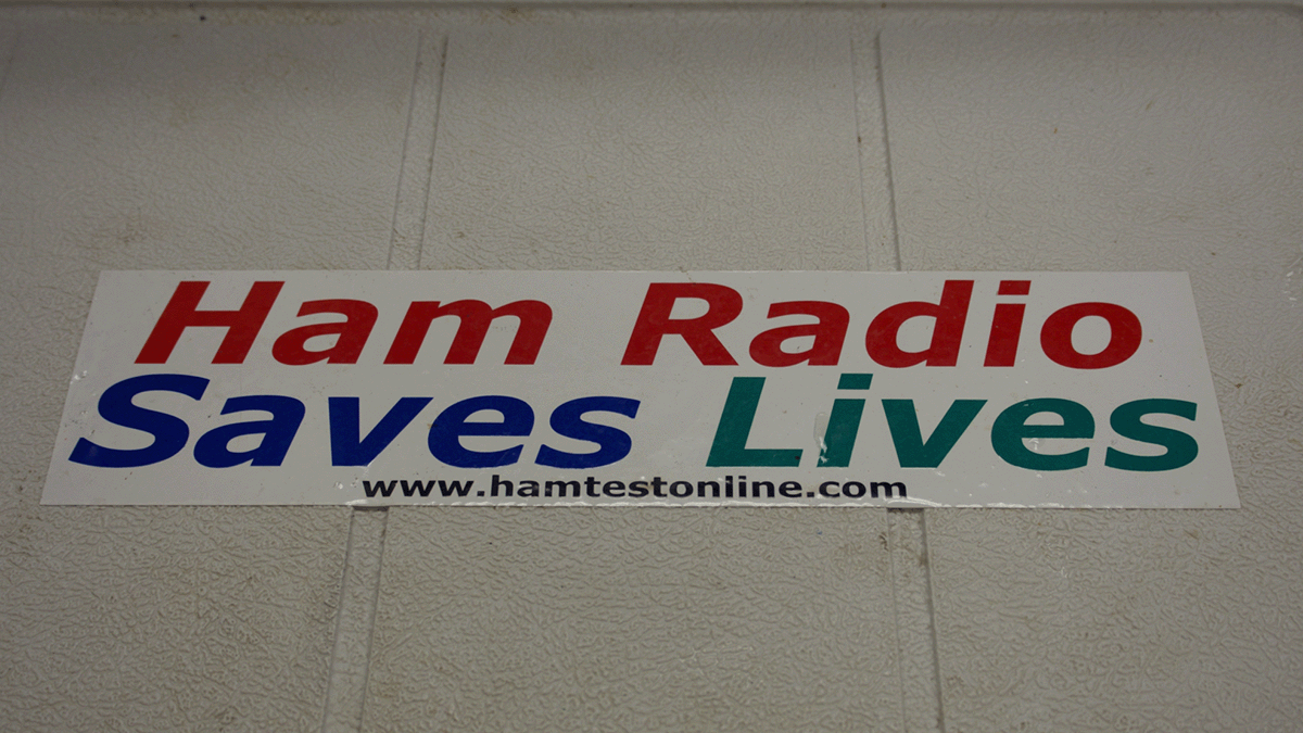 A sticker displayed in a Ham Radio Club in the Midwest, reading "Ham Radio Saves Lives, www.hamtestonline.com." Photo: María Arce