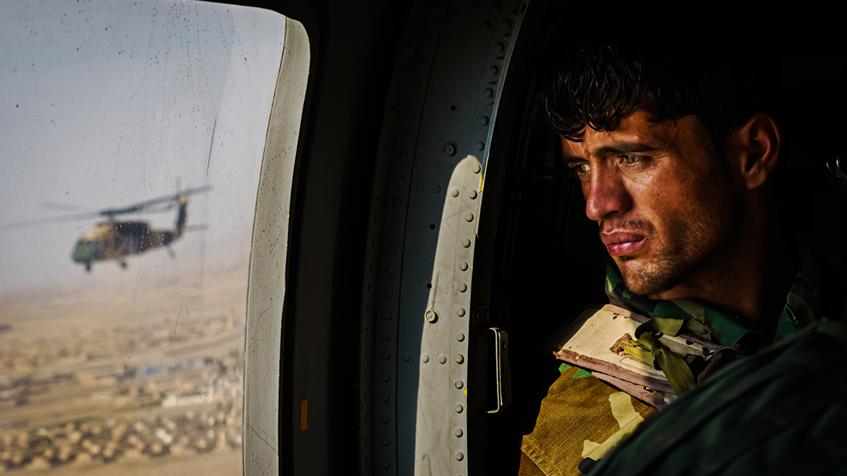 A soldier surveys the terrain out of the window of a UH-60 Black Hawk during a resupply flight toward an outpost in the Shah Wali Kot district north of Kandahar, Afghanistan, on May 6, 2021. The Afghan Air Force, which the U.S. and its partners have nurtured to the tune of $8.5 billion since 2010, is now the government’s safeguard in its fight against the enemy. Since May 1, the original deadline for the U.S. withdrawal, the Taliban have overpowered government troops, wrestling away control of territories and further denying Afghan security forces the use of roads. As a result, all logistical support to thousands of outposts and checkpoints — including re-supplies of ammunition and food, medical evacuations, or personnel rotation — must be done by air.