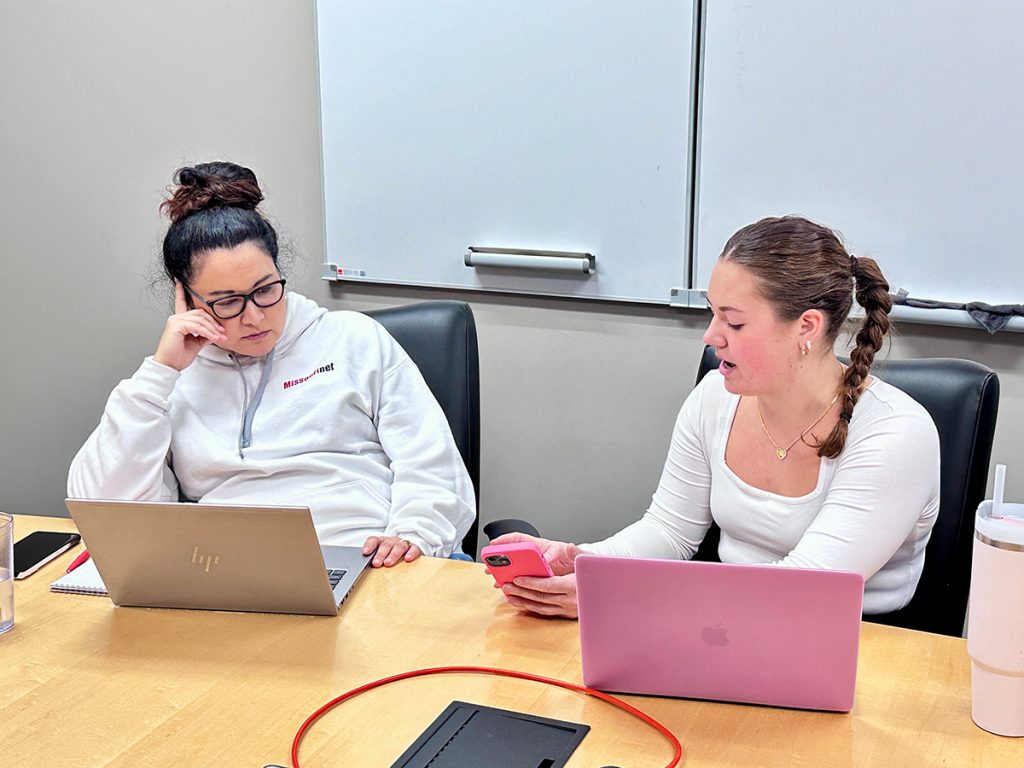 Elise Newman, right, uses her smartphone to demonstrate an Instagram feature to Alisa Nelson, left, news director of Missourinet, on Jan. 16, 2025, in Jefferson City, Missouri.