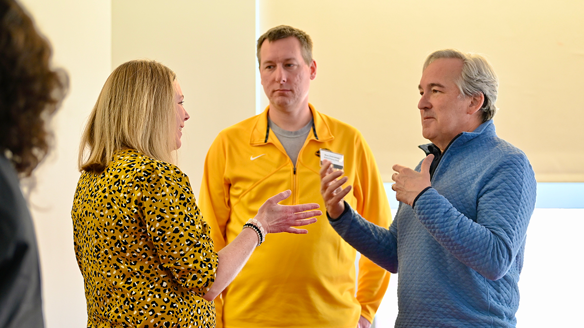 News professionals from across the country gathered at the Reynolds Journalism Institute on March 6-7, 2025, to brainstorm ways to introduce four-day workweeks into newsrooms. Elizabeth Frogge, left, managing editor at KOMU-TV; Stan Jastrzebski, news director at KBIA 91.3 FM; and Andrew Finlayson, executive vice president of digital and AI strategies at SmithGeiger Group, huddle Friday morning during a discussion on implementation plans.