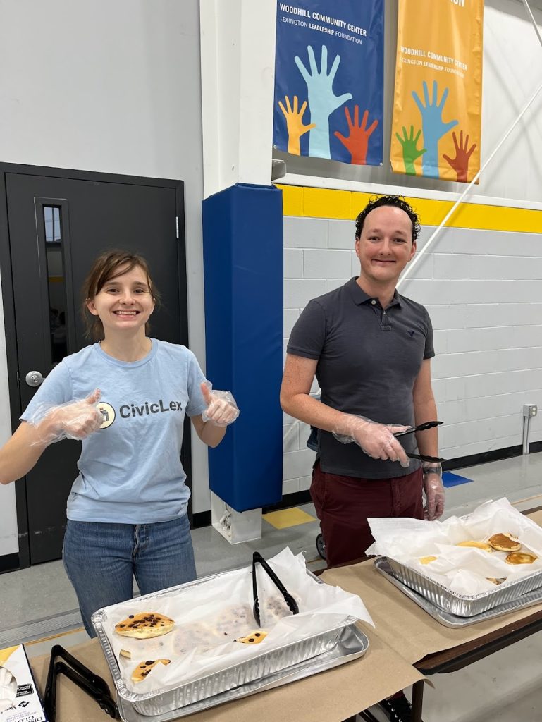 A girl and a man serving food.