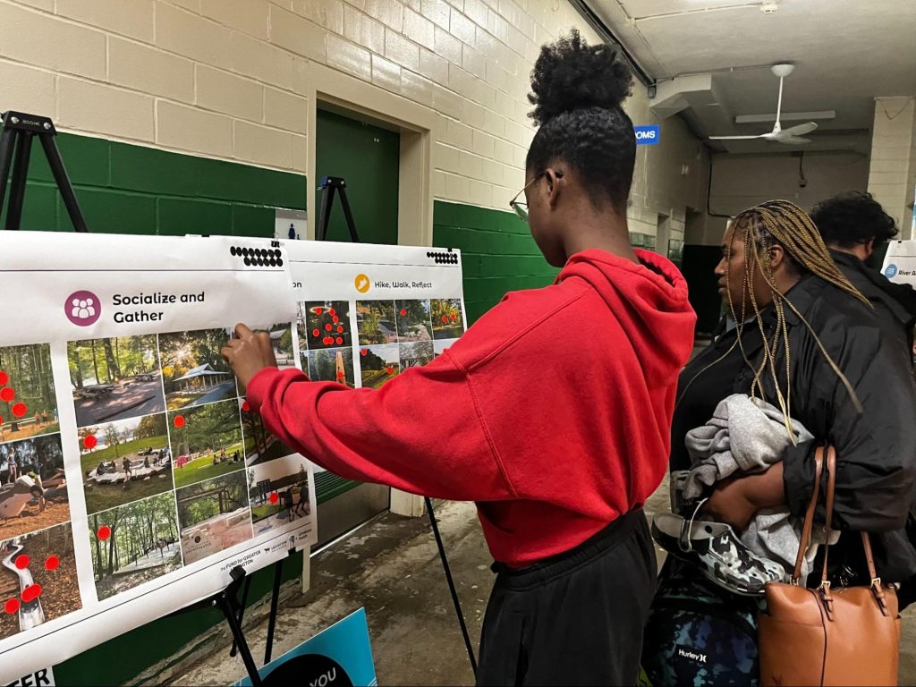 Woman sticks pin into a poster with several photos.