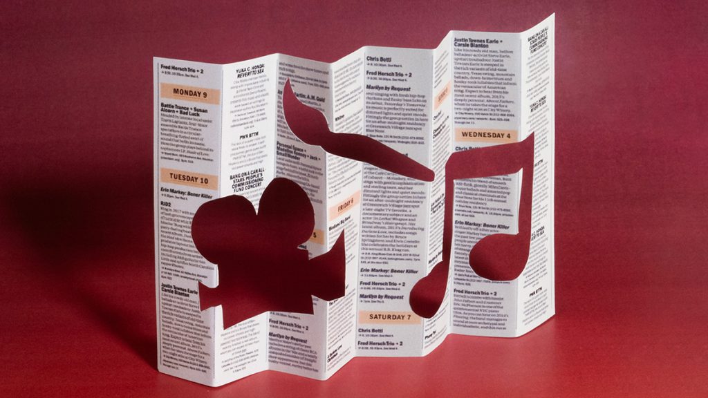 A brochure standing up on a table with the images of a film camera, a paint brush and a musical note cut out of the paper. Image: Ben Denzer | The Atlantic