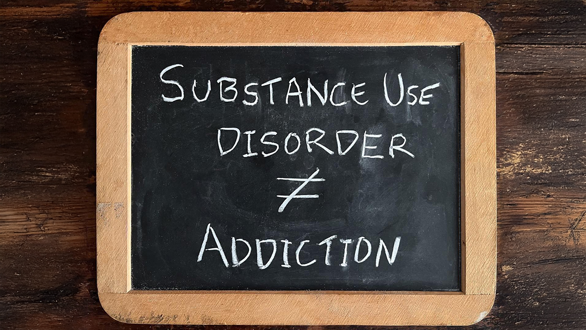 Handheld chalkboard with written on it "Substance use disorder ≠ addiction."