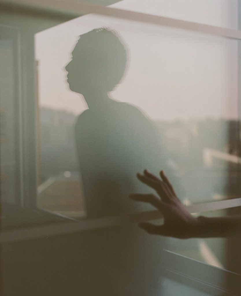 Silhouette of anonymous person reflected in a window