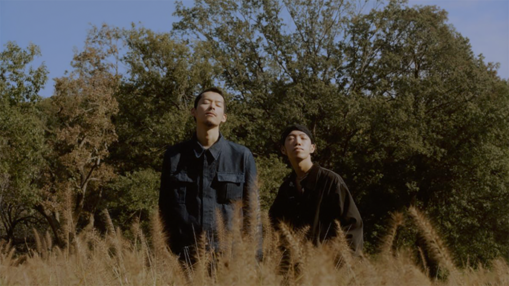 Two men standing in a field.