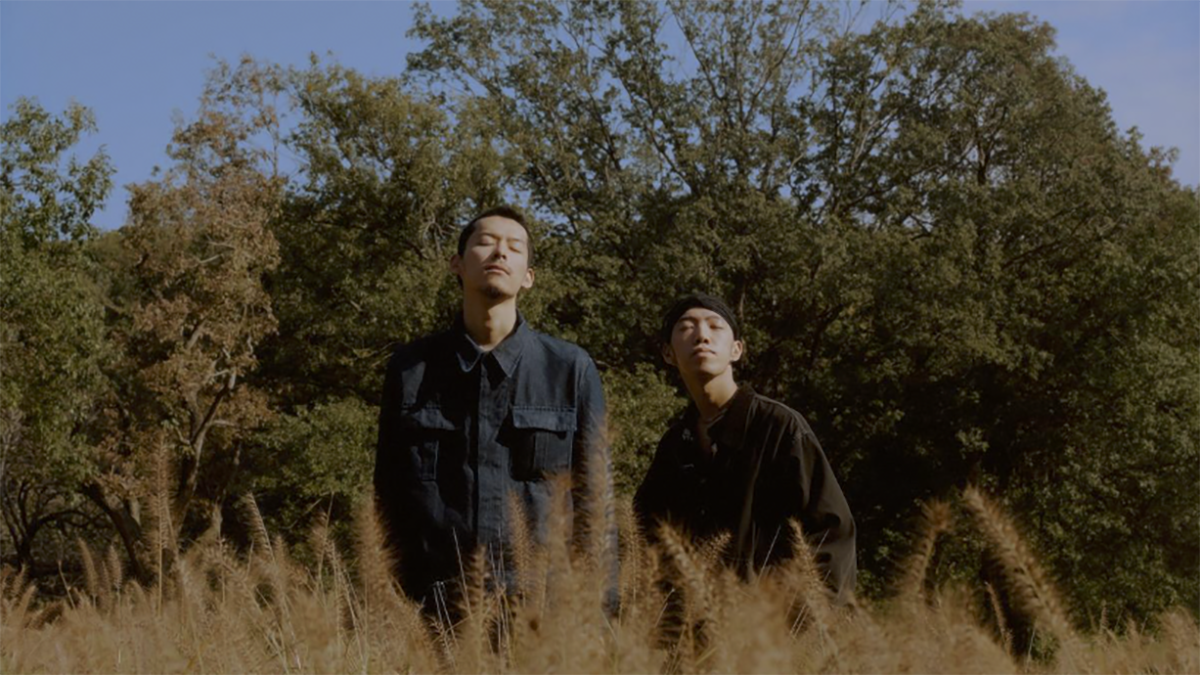 Two men standing in a field.