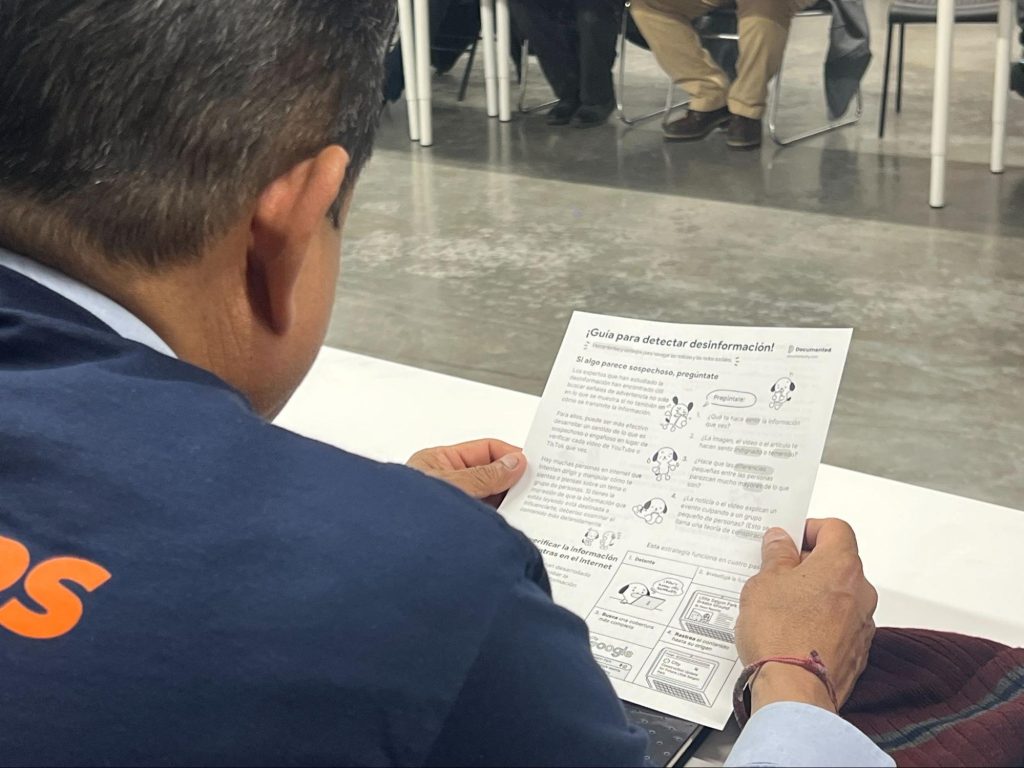 A workshop participant holding a Spanish translation of a misinformation tipsheet in February 2025. Photo: Lam Thuy Vo