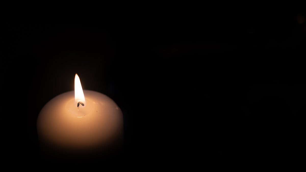A lit candle in the dark.