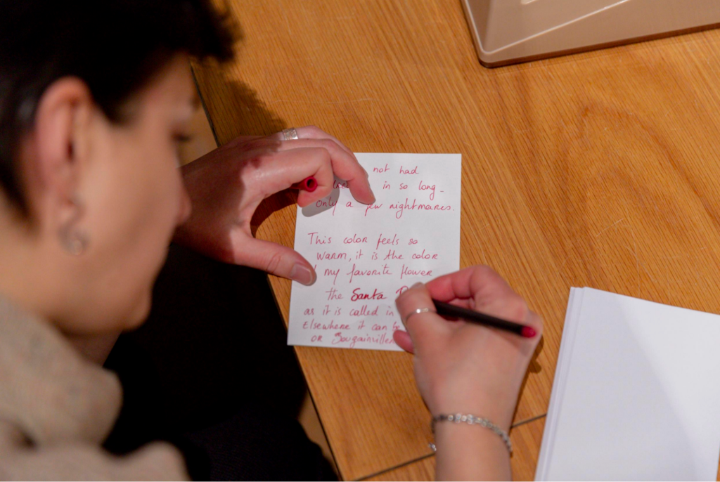 Woman writes a note with a red ink pen.
