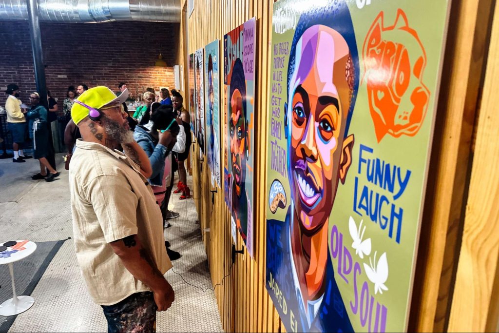 Visual artist Cbabi Bayoc listens to the audio accompanying the portraits he created during the launch of Remember Me. Photo: Brian Munoz | St. Louis Public Radio