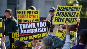 Protesters holding signs in support of a free press.