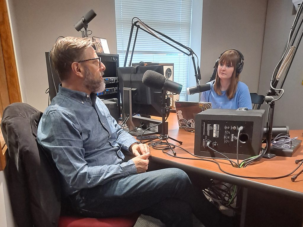Kiana Fernandes, BJ '24, MA '26, interviews guest critic Sam Adams in the KBIA studio. Photo: Rebecca Ritzel